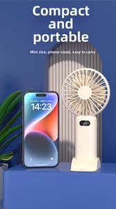 Compact white handheld fan with digital display shown next to a smartphone for size