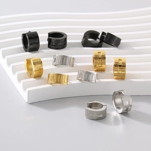 Detail of titanium steel earrings with Roman numerals and cross designs in black, gold, and silver