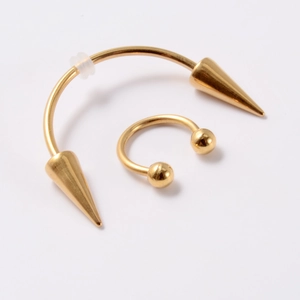 Macro shot of gold stainless steel vampire smile fangs and horseshoe nose ring piercings