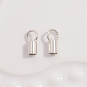 Close-up of S925 sterling silver cord end caps with loops for jewelry making and beading
