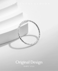 Close-up of S925 sterling silver ring with diamond-cut texture on white geometric steps