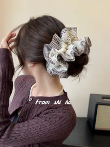 Detail of layered houndstooth and lace scrunchie shown in a stylish updo hairstyle