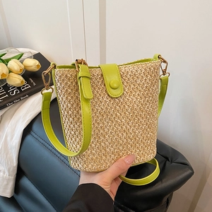 Summer woven straw bucket bag with bright green leather straps for beach vacation
