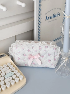 Detail of pink rose quilted makeup bag with white lace trim and pink satin bow