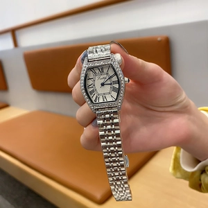 Close-up of elegant tonneau-shaped women's silver watch with rhinestones and Roman numerals