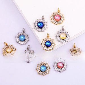 Macro shot of gold-plated sun-shaped jewelry charms with colorful gemstone centers