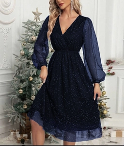 Close-up of deep blue V-neck dress with sparkling star sequins on mesh sleeves