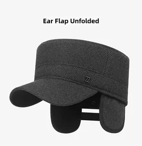Detail of dark grey tweed winter cap for men showing unfolded ear flaps and metal logo