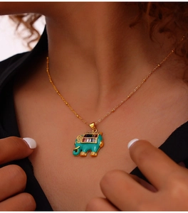 Close-up of gold-plated elephant necklace with colorful crystals and turquoise enamel
