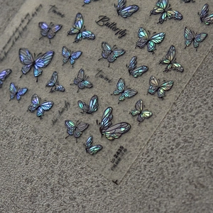Macro detail of laser holographic butterfly nail stickers with blue aurora reflective finish