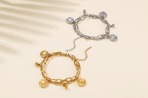 Detail of double-layer titanium steel bracelet with sunburst coin and metallic beads