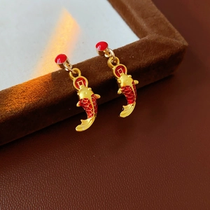 Détail de boucles d'oreilles carpe koï avec motifs de pièces d'or et écailles rouges
