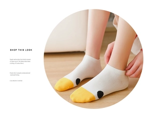Close-up of white cotton ankle socks with yellow duck toe design and black polka dots