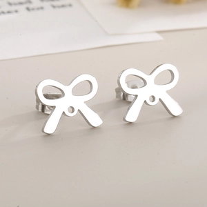 Close-up of silver hollow bow stud earrings with polished stainless steel finish
