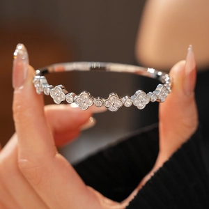 Macro shot of clover shaped bangle with sparkling zircons and fine silver finish