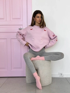 Detailed close-up of pink knit sweater featuring high-quality dachshund dog embroidery