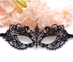 Detail of black lace masquerade mask with purple rhinestones and intricate floral patterns