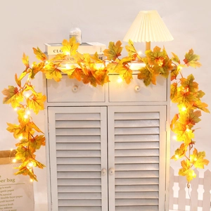 Close-up of maple leaf LED string lights hanging on a white cabinet for autumn decor