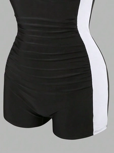 Detailed close-up of ruched black and white swimwear fabric showing stitching and texture