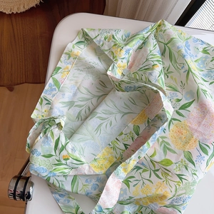 Detail of floral cotton tote bag with vintage leaf pattern on white surface