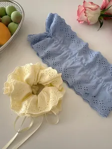 Close-up of premium lace scrunchies in yellow and blue with intricate embroidery