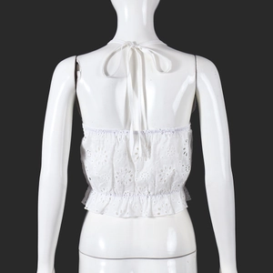 Detail view of white eyelet lace halter top with back tie design and ruffled waist