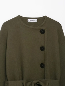 Detail der armee-grünen Strickjacke mit schwarzen Knöpfen und passendem Gürtel-Detail