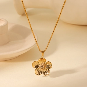Detailed macro of gold flower pendant with sparkling crystals and a twist chain