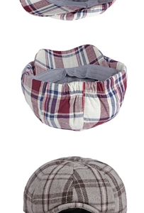 Detail of plaid newsboy hats showing elastic back straps and wool blend texture