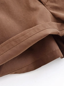 Macro detail of brown cotton fabric showing precise stitching and smooth woven texture