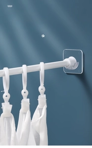 Support de tringle télescopique adhésif avec crochets blancs sur mur bleu foncé