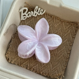 Macro shot of lilac flower hair claw clip with marble texture in a gift box