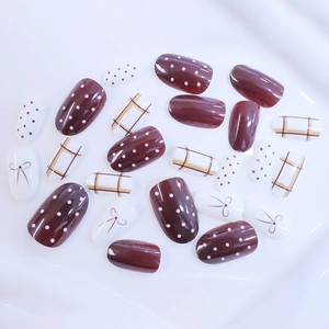 Short oval press-on nails set with red and white plaid polka dot bow patterns