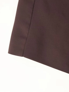 Detail view of deep brown twill fabric with clear weaving texture and stitched edge