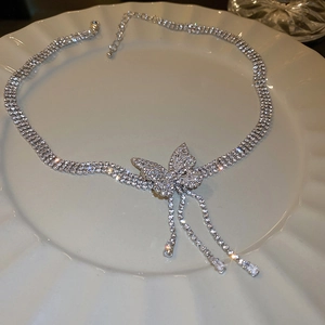 Détail du pendentif papillon argenté avec franges en strass et fermoir mousqueton