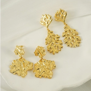 Macro view of 18K gold plated lava earrings with irregular leaf and hollowed coral designs