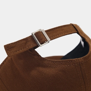 Detailed macro view of the brown cotton cap back with adjustable silver metal buckle