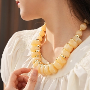 Détail du collier vintage avec de grandes perles jaunes et des séparateurs dorés