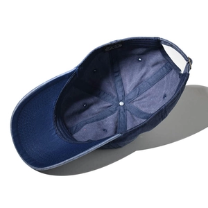Detailed interior of blue cotton baseball cap showing 100% cotton label and stitching