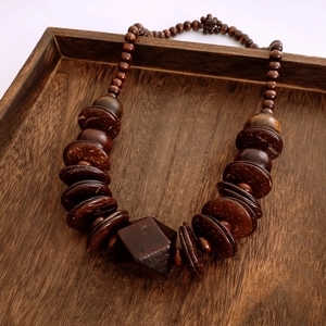 Detailed texture of vintage wood beads and coconut shell discs on ethnic sweater necklace