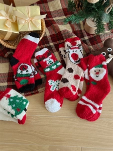 Detail showing various Christmas coral fleece socks with festive patterns and thick texture