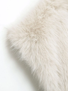 Dettaglio della texture in ecopelliccia beige morbido su un gilet corto a pelo lungo