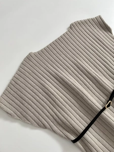 Detail of ribbed knit fabric texture with slim black leather belt and gold metal buckle