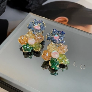 Vue macro de boucles d'oreilles fleurs en cristal coloré avec perles d'opale