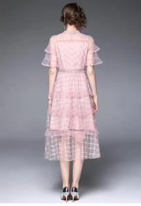 Détail de la robe féerique rose avec broderie dorée sur tulle et manches à volants