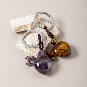 Detail of woven heart-shaped amethyst and tiger eye natural stone keychains