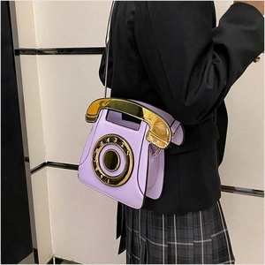 Macro detail of lavender phone-shaped crossbody bag with gold dial and numeric sequins