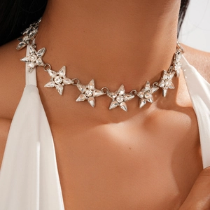 Dettaglio di una collana a stella in argento con cristalli scintillanti sul collo