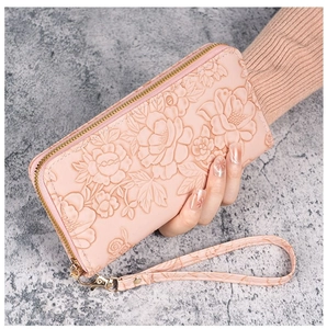 Detail of pink long wallet featuring 3D rose floral embossing and gold zipper closure