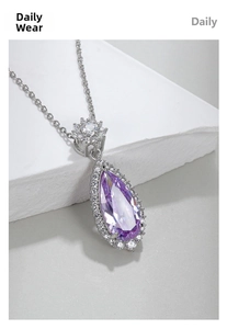 Macro shot of a pear-shaped purple gemstone pendant on a white textured stone surface